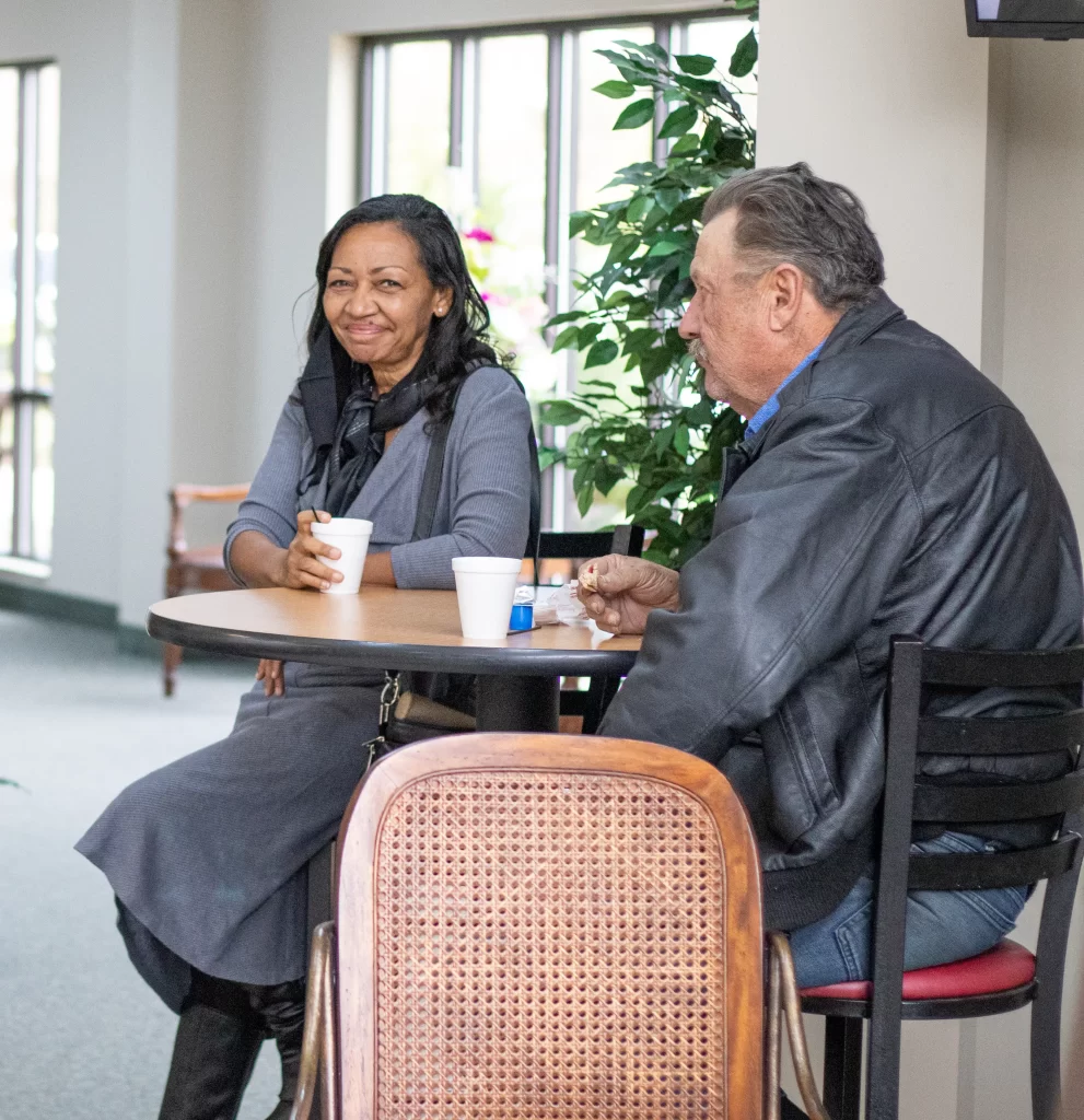 Woman and Man sitting at a table enjoying coffee